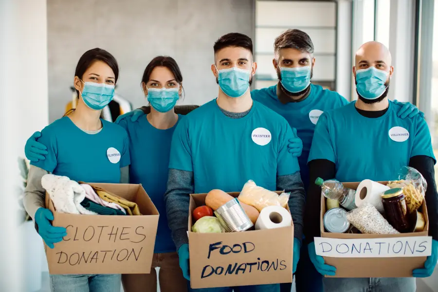 team-volunteers-holding-donation-boxes-looking-camera