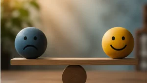 Blue sad-faced ball and yellow happy-faced ball balance on a wooden seesaw, symbolizing contrast in mood or balance of emotions.